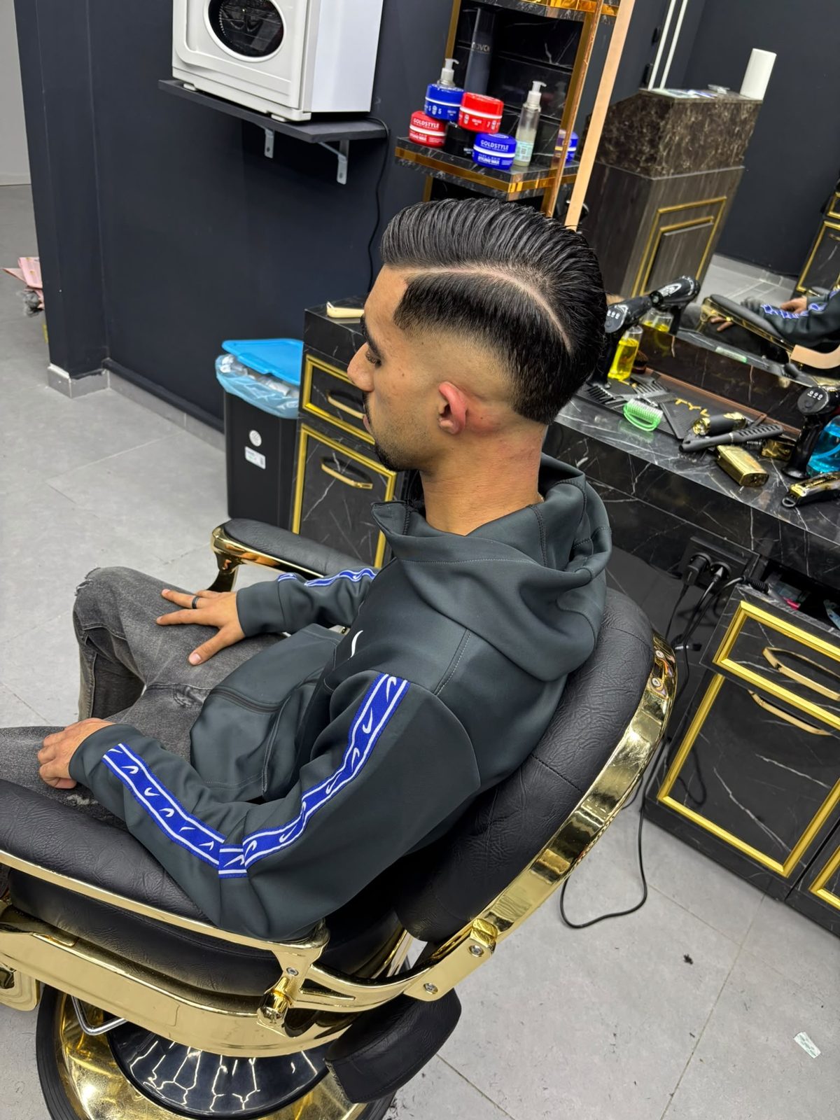 Capelli pettinati con riga laterale rasata e skin fade