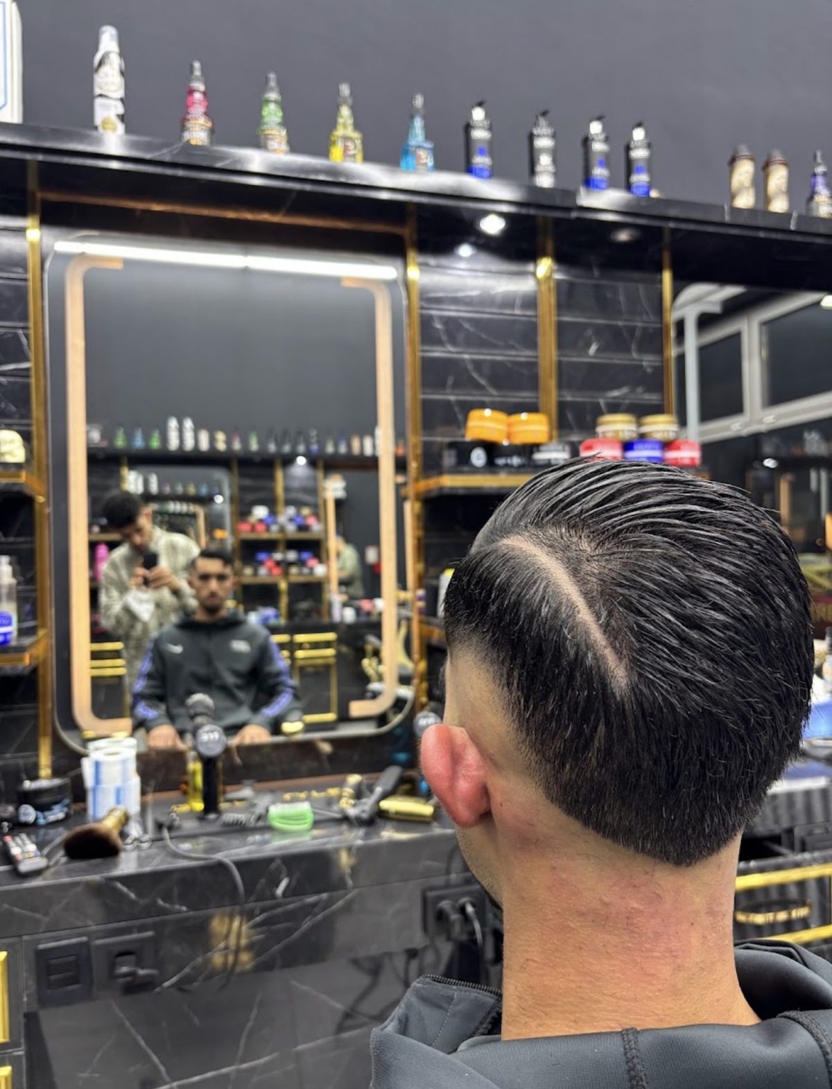 Capelli pettinati all'indietro con riga rasata e sfumatura bassa